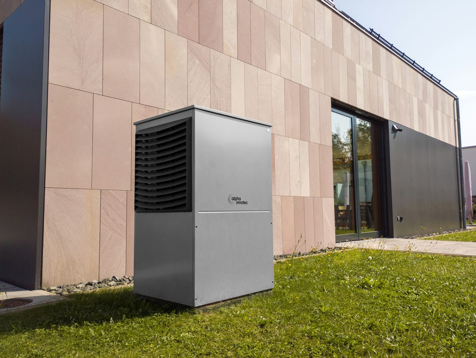 Moderne warmtepomp-buitenunit naast een woning